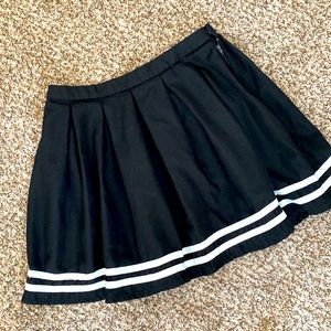 Pleated black skirt with trim detail.